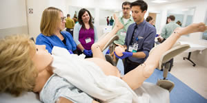 Dr. Goffman supervises students in the delivery of a baby using Noelle, a mannequin simulator