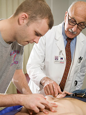 Dr. Cohen guides a student through the examination of a patient