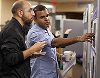 Students and postdocs discuss their work during the poster session