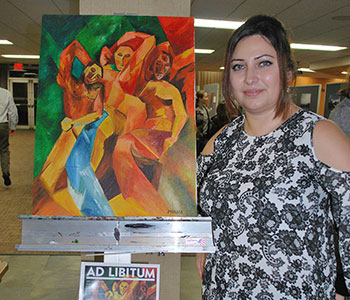 Mirna Jaber shows off one of several paintings she had on display; this piece has graced the cover of Ad Libitum