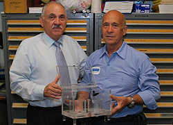 Tony Leggiadro (right) holds one of the instruments he devised at the request of Einstein investigators, with his supervisor, Richard Civitano