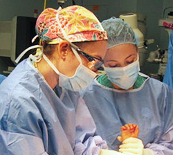 Stacey Frisch observes Dr. Nicole Nemeth’s technique during surgery on a young patient