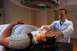 With the aid of a technician, a head-and -neck cancer patient undergoes radiation therapy at Montefiore Medical Center. 