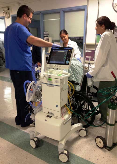 members of the Montefiore Medical Center ICU physical therapy team help an ICU patient with early mobilization therapy