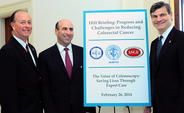 Dr. David Greenwald holds entry sign for 2014 Capitol Hill colonoscopy debriefing